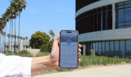 A hand holding up a phone that is showing the ZeeMee platform on the screen